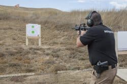 Photo of a man shooting a rifle and the gun range