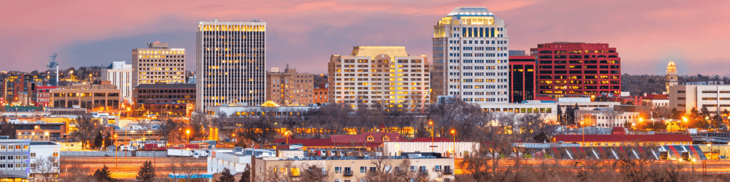 The image features a landscape view of downtown Colorado Springs
