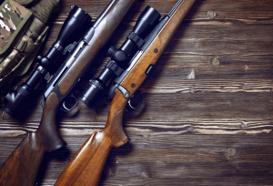 two wooden rifles on wood background