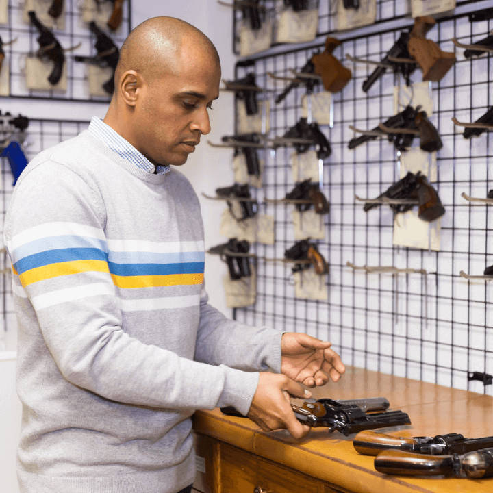 a picture of a firearm expert holding firearms in a gun store
