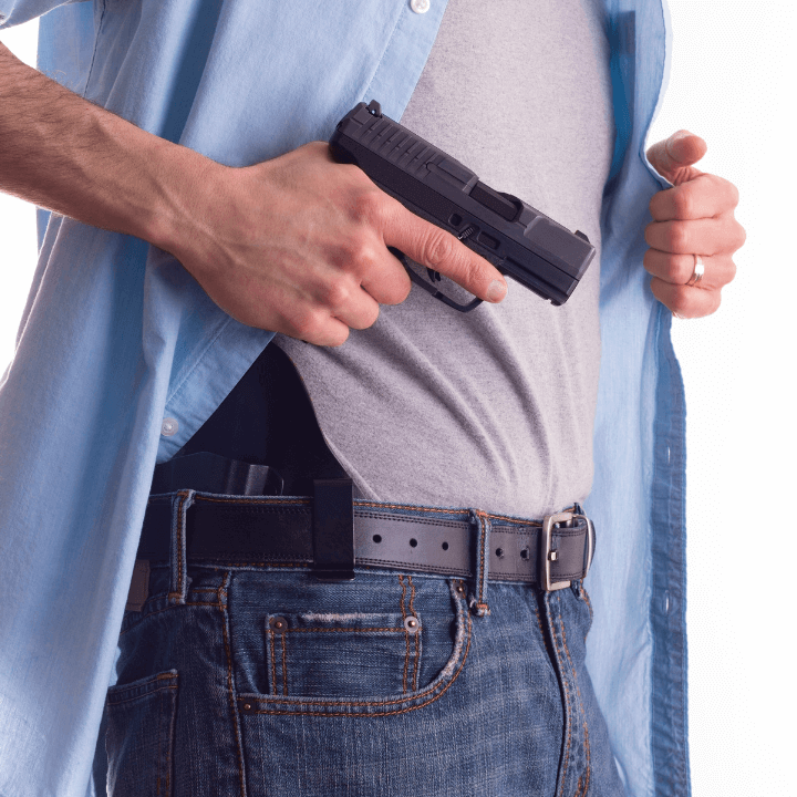 The image shows a man with a holster on his belt holding a handgun.