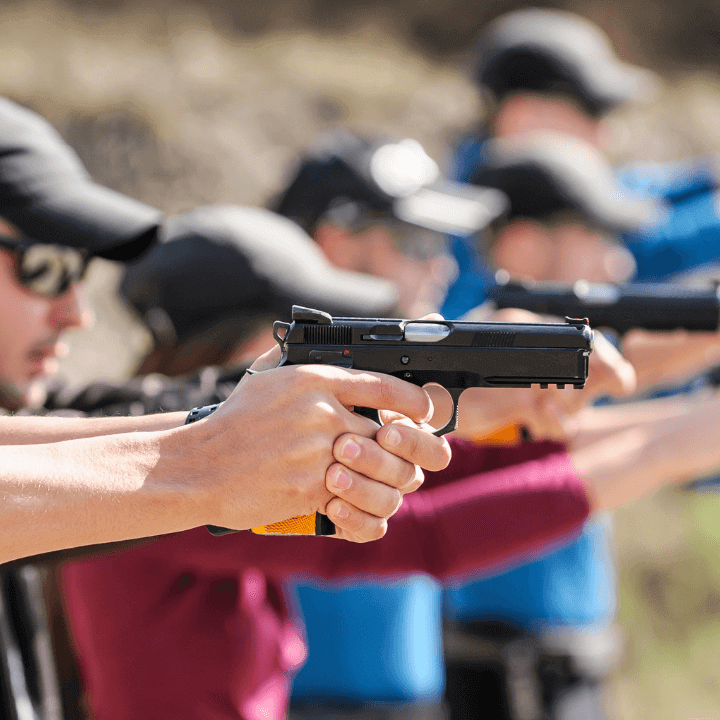 This image shows a bunch of students in a CCW permit class lined up and practicing their aim.