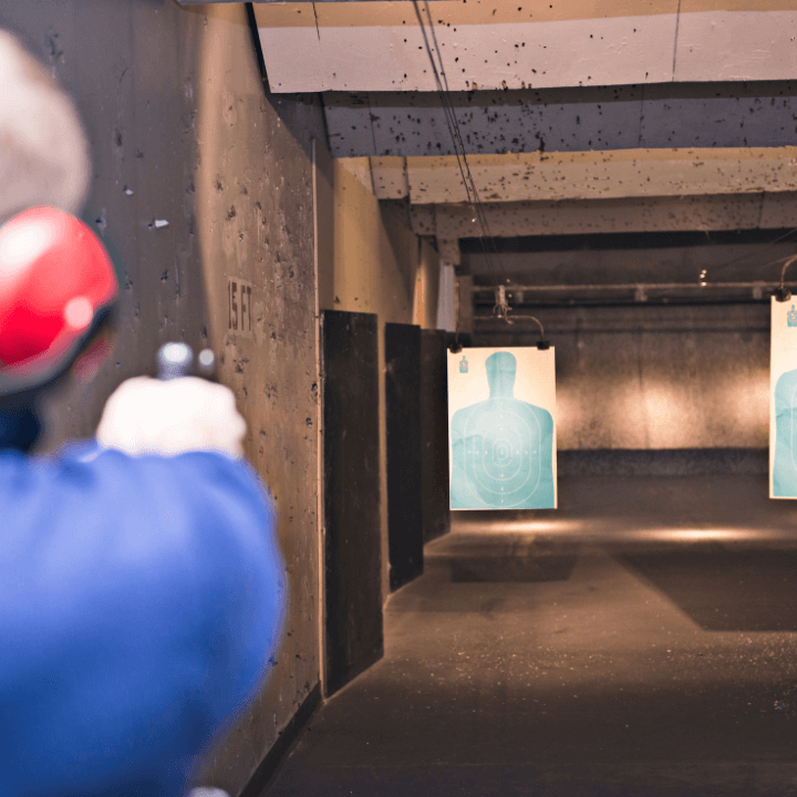 A picture of someone shooting a handgun in a shooting range.