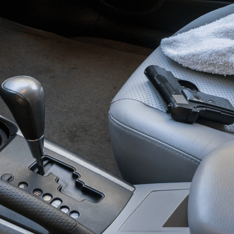 A gun sitting unattended in the passenger seat of a car