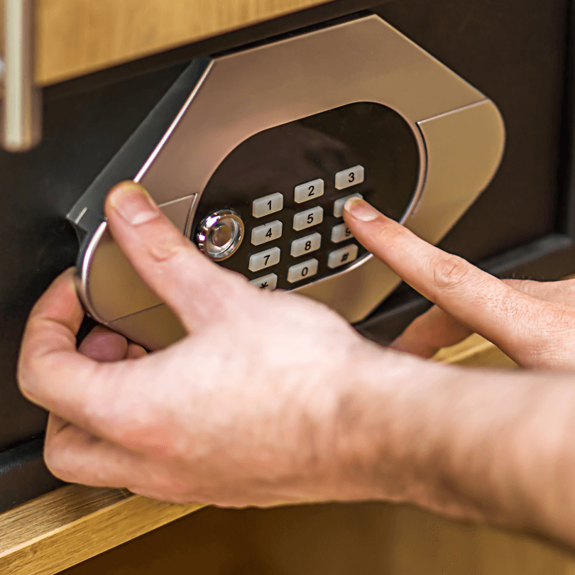 a closeup of someone closing and setting the code on a hotel safe