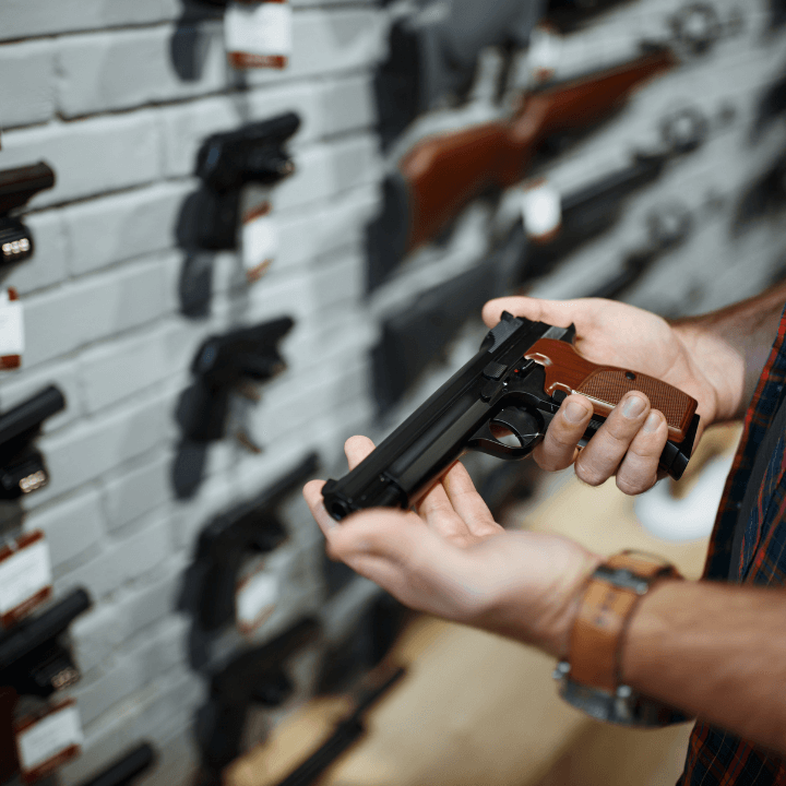 A closeup of someone examining a gun in a shop
