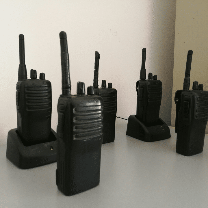 A few walkie talkies on chargers standing up