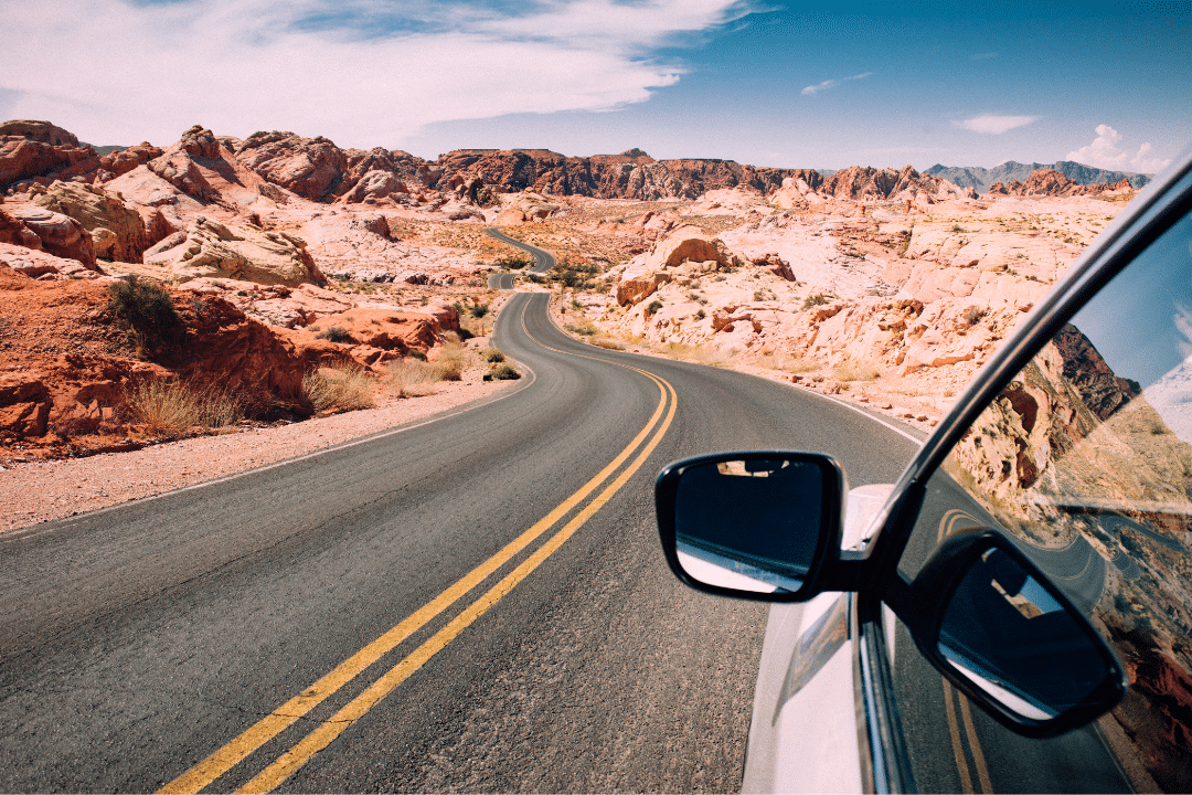 View of driver's side mirror as car goes down the highway.