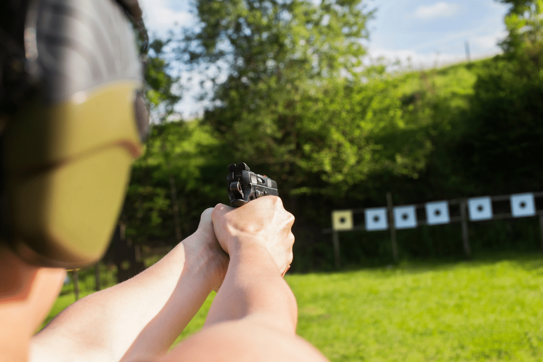 Practicing firearm safety with handgun at shooting range.