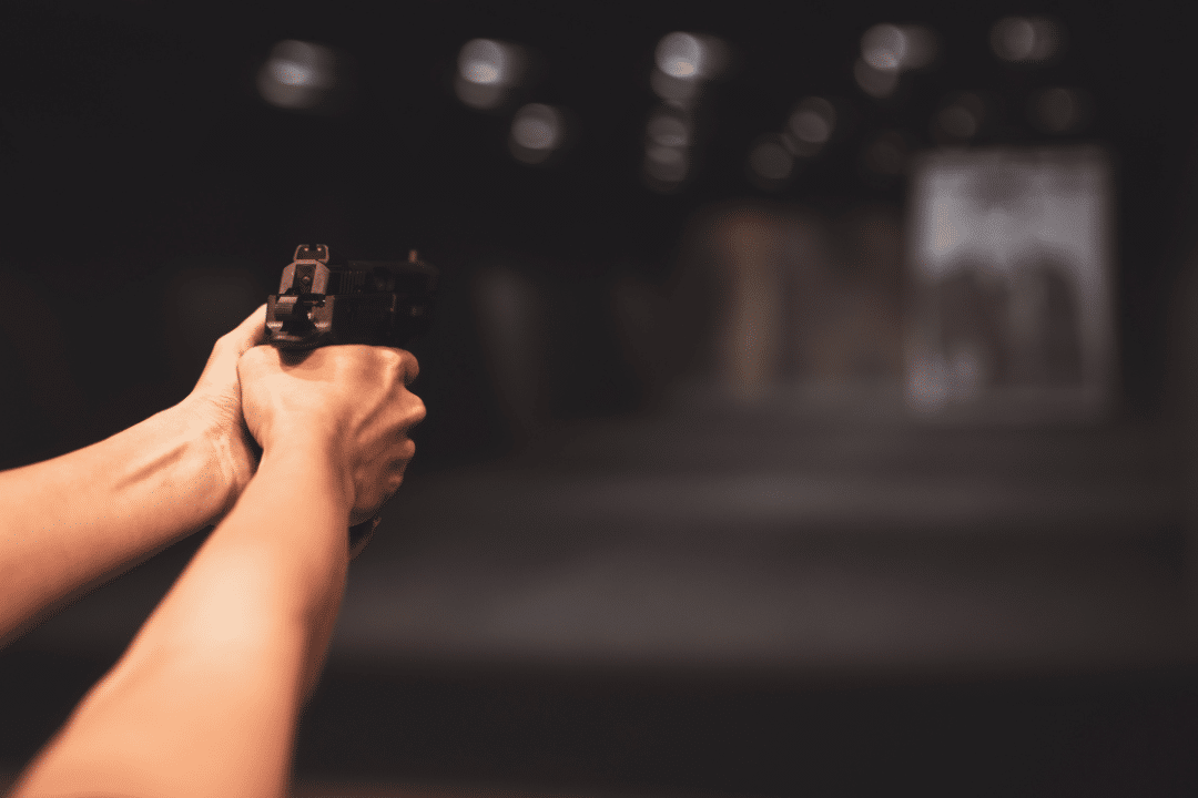 Firing a handgun at the shooting range.